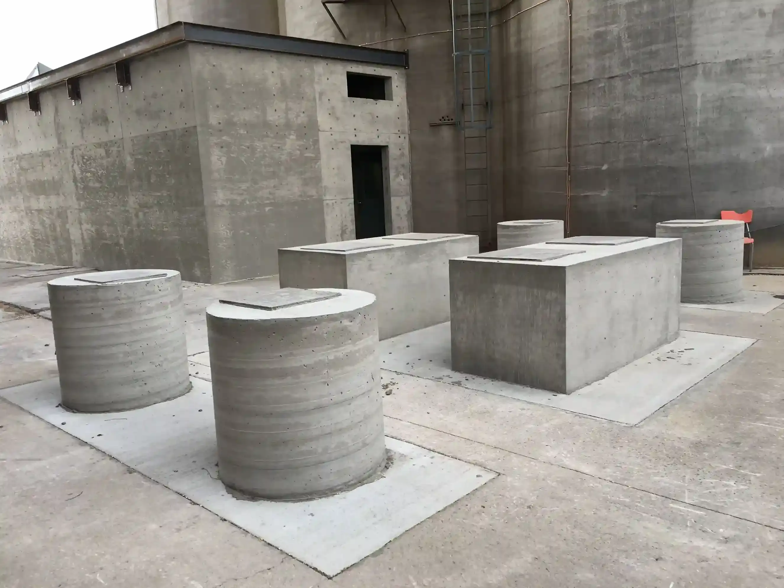 Concrete cylinders and blocks in an industrial setting.