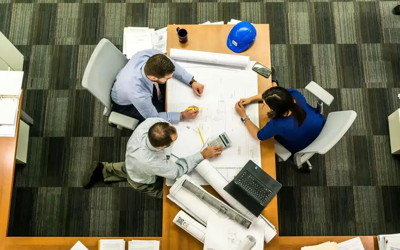Team reviewing project plans at a desk.