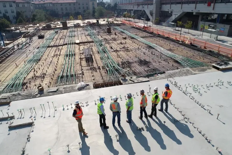 Construction workers discussing progress at a large construction site.